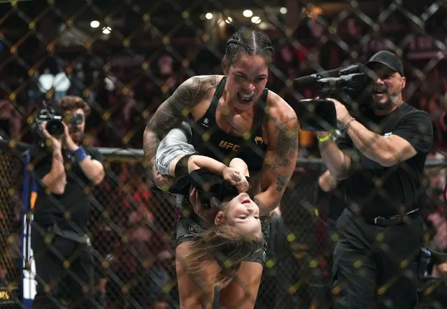 Amanda Nunes celebrates with her daughter after defeating Irene Aldana in a UFC 289 bout to hold on to her bantamweight title, in Vancouver, British Columbia, on Saturday, June 10, 2023. Nunes announced her retirement following the fight. (Photo by Darryl Dyck/The Canadian Press via AP Photo)