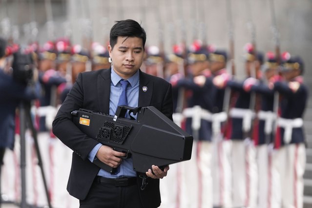 A security detail member of Vietnam's President Luong Cuong holds a drone shield during a welcoming ceremony at the Palace of Justice, on the sidelines of the Asia-Pacific Economic Cooperation (APEC) summit, in Lima, Peru, Wednesday, November 13, 2024. (Photo by Fernando Vergara/AP Photo)
