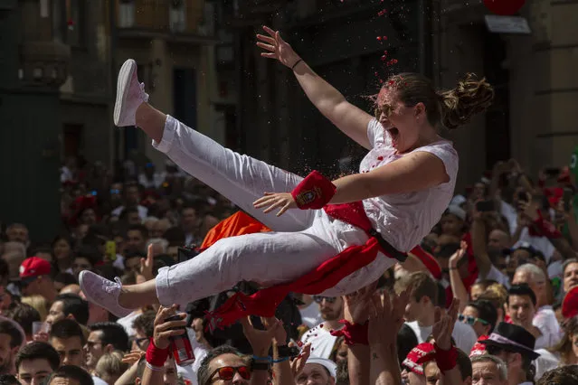 Revellers enjoy the atmosphere during the opening day or “Chupinazo” of the San Fermin Running of the Bulls fiesta on July 6, 2018 in Pamplona, Spain. The annual Fiesta de San Fermin, made famous by the 1926 novel of US writer Ernest Hemmingway entitled “The Sun Also Rises”, involves the daily running of the bulls through the historic heart of Pamplona to the bull ring. (Photo by Pablo Blazquez Dominguez/Getty Images)