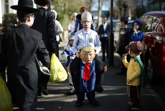 A child dressed as Britain's Prime Minister Boris Johnson and former U.S. President Donald Trump celebrates the annual holiday of Purim, amid the coronavirus disease (COVID-19) pandemic, at Stamford Hill in London, Britain on February 26, 2021. (Photo by Henry Nicholls/Reuters)