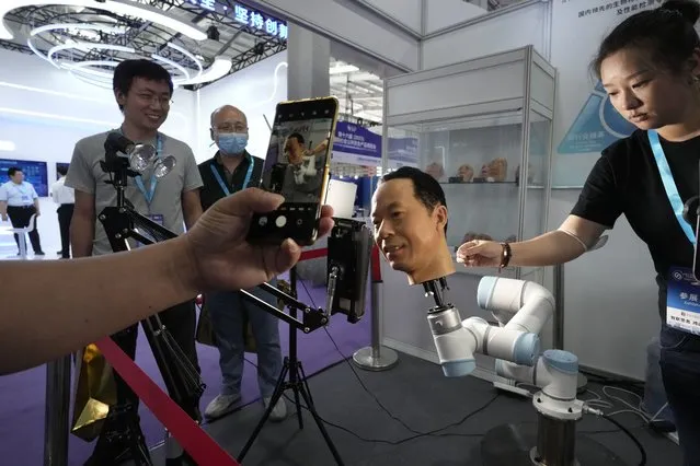 A visitor films a life-like head used to test biometric technologies to combat fraud during the Security China 2023 in Beijing, on June 7, 2023. (Photo by Ng Han Guan/AP Photo)