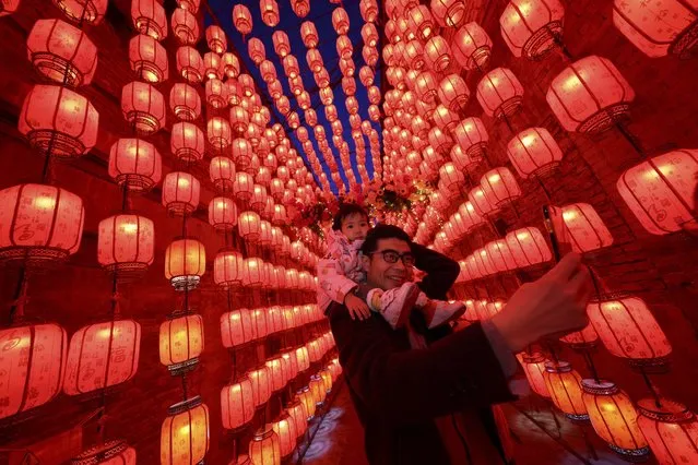 People take photos next to a display of lanterns decorated with lights during the Lantern Festival, which marks the end of the Lunar New Year celebrations in Taiyuan, in northern China's Shanxi province on February 26, 2021. (Photo by AFP Photo/China Stringer Network)