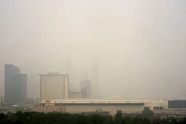 The Marriott Marquis, left, and the Hyatt Regency McCormick Place, center, stand above The McCormick Place Convention Center in a veil of haze from Canadian wildfires obscuring the majestic Chicago skyline, as seen from the city's Bronzeville neighborhood Tuesday, June 27, 2023, in Chicago. (Photo by Charles Rex Arbogast/AP Photo)