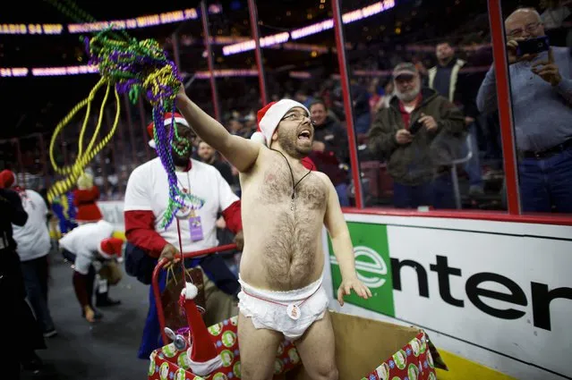 A supporter of a participant at the 23rd annual Wing Bowl hurls beads into the crowd during a parade at the Wells Fargo Center in Philadelphia, Pennsylvania January 30, 2015. (Photo by Mark Makela/Reuters)