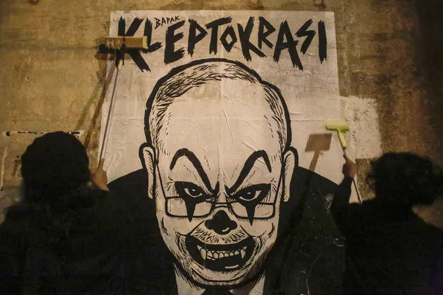 Activist and artist Fahmi Reza (R) and his friend mount a caricature poster depicting Najib with a clown face ahead of Bersih 5.0 Rally in Kuala Lumpur, Malaysia, 17 November 2016. Fahmi Reza was charged on 06 June 2016 with violating multimedia laws by caricaturing Prime Minister Najib Razak with a clown face. Particicants of the Bersih 5.0 rally will march to the Independent Square in Kuala Lumpur at 19 November 2016. (Photo by Azry Ismail/EPA)
