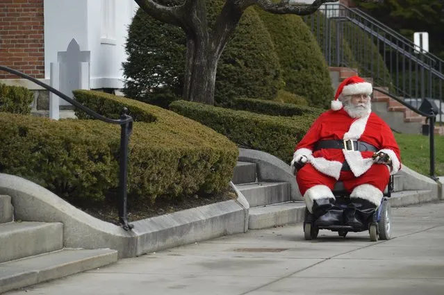 Ken Keefner, dressed as Santa, rides his wheelchair on Park Square in Pittsfield, Mass., Wednesday, December 23, 2015. Record warmth was expected on Christmas Eve along the East Coast, said Bob Oravec, lead forecaster with the National Weather Service. (Photo by Ben Garver/The Berkshire Eagle via AP Photo)