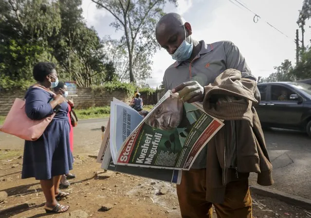 A man reads a copy of the Daily Nation morning newspaper reporting the death of neighboring Tanzania's President John Magufuli on a street in Nairobi, Kenya Thursday, March 18, 2021. Magufuli, a prominent COVID-19 skeptic whose populist rule often cast his country in a harsh international spotlight, died Wednesday aged 61 of heart failure, it was announced by Vice President Samia Suluhu. Headline in Swahili reads “Goodbye Magufuli”. (Photo by Khalil Senosi/AP Photo)