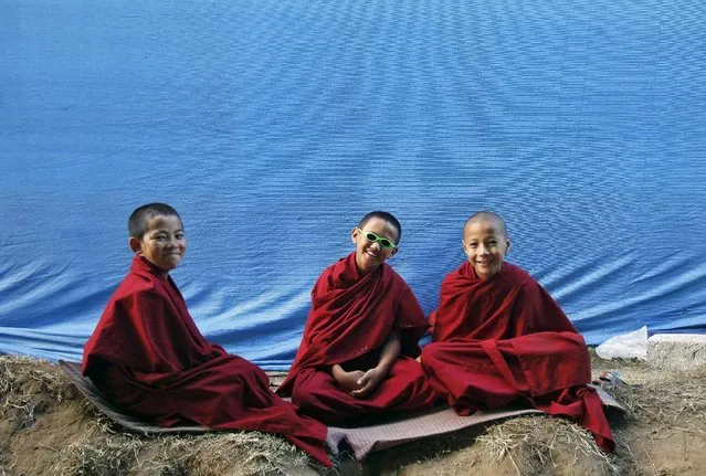 Novice Buddhist monks react to the camera during the Jangchup Lamrim teachings conducted by the Tibetan spiritual leader the Dalai Lama (not pictured) at the Tashi Lhunpo Monastery in Bylakuppe in Karnataka, India, December 25, 2015. (Photo by Abhishek N. Chinnappa/Reuters)