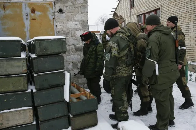 Pro-Russian separatists inspect boxes with ammunition used by Ukrainian government troops in the town of Vuhlehirsk, eastern Ukraine February 10, 2015. (Photo by Maxim Shemetov/Reuters)