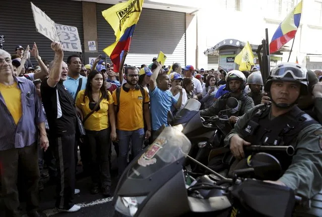 Supporters of Venezuela's opposition face motorized police officers who are blocking a street leading to the building housing the National Assembly in Caracas, January 5, 2016. (Photo by Marco Bello/Reuters)