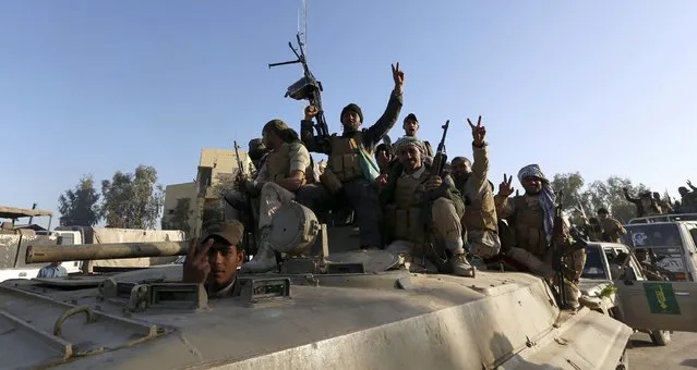 Iraqi security forces and Shi'ite fighters sit on a tank in the Salahuddin province March 2, 2015. Iraq's armed forces, backed by Shi'ite militia, attacked Islamic State strongholds north of Baghdad on Monday as they launched an offensive to retake the city of Tikrit and the surrounding Sunni Muslim province of Salahuddin.     REUTERS/Thaier Al-Sudani 