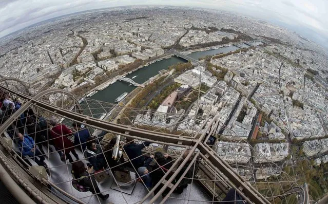 Tourists look over the French capital from the third floor of the Eiffel Tower on an overcast day in Paris, France, November 4, 2015. (Photo by Philippe Wojazer/Reuters)