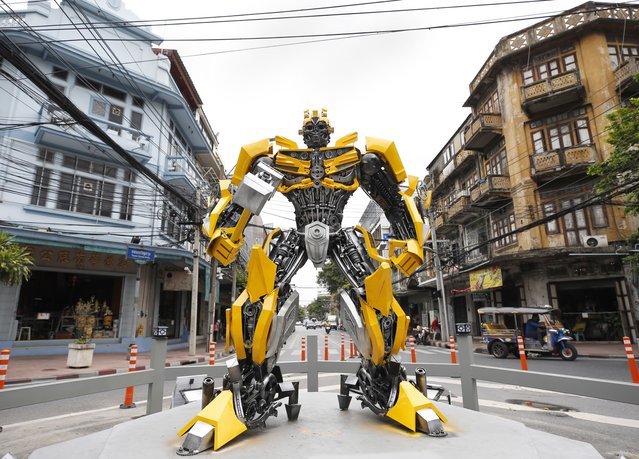 A large-scale figure of Bumblebee, a fictional character from the USA film Transformers, displayed at an intersection in Bangkok, Thailand, 31 July 2023. Thai authorities made a large-scale figure of Bumblebee and displayed it on a circle as a traffic sign for the driver's gaze to pay attention in an effort to prevent road accidents on a busy intersection as well as street decoration to attract tourists. (Photo by Rungroj Yongrit/EPA)