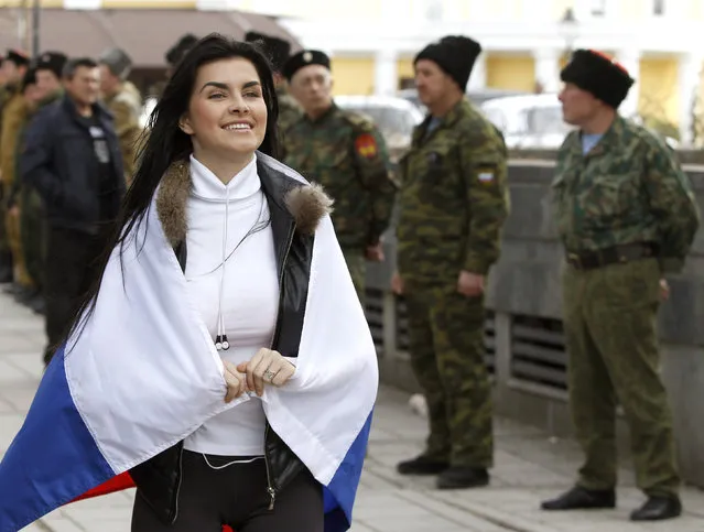 A pro-Russian supporter with the Russian national flag on her shoulders takes part in a meeting in Simferopol, March 6, 2014. (Photo by Vasily Fedosenko/Reuters)