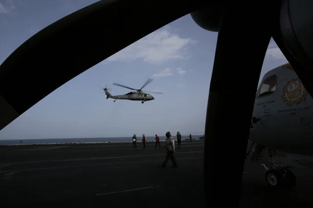 A U.S. military helicopter takes off from the flight deck of the USS Carl Vinson aircraft carrier in the Persian Gulf, Thursday, March 19, 2015. (Photo by Hasan Jamali/AP Photo)