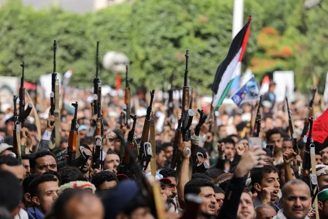 People hold up their weapons during a protest to express solidarity with the Palestinian people amid a flare-up of Israeli-Palestinian violence, in Sanaa, Yemen on May 17, 2021. (Photo by Khaled Abdullah/Reuters)