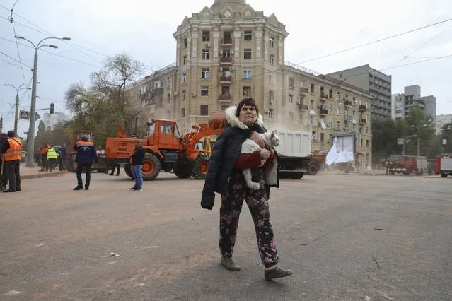 A local resident carries a cat as she passes by an apartment building damaged in the Russian rocket attack in central Kharkiv, Friday, October 6, 2023. (Photo by Alex Babenko/AP Photo)