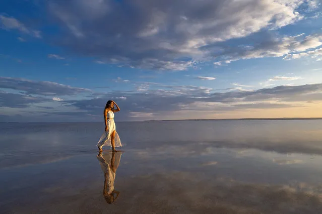 A woman walks on Lake Salt, which is on the UNESCO World Heritage Tentative List, during the sunset in Ankara, Turkiye on July 3, 2023. Lake Salt, which is one of the important wetlands of Turkiye and is of great importance for the protection of biological diversity in our country, also attracts the attention of visitors. (Photo by Aytac Unal/Anadolu Agency via Getty Images)