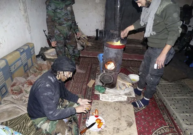Rebel fighters prepare food while resting in a safehouse in the northwestern Homs district of Al Waer January 18, 2015. (Photo by Reuters/Stringer)