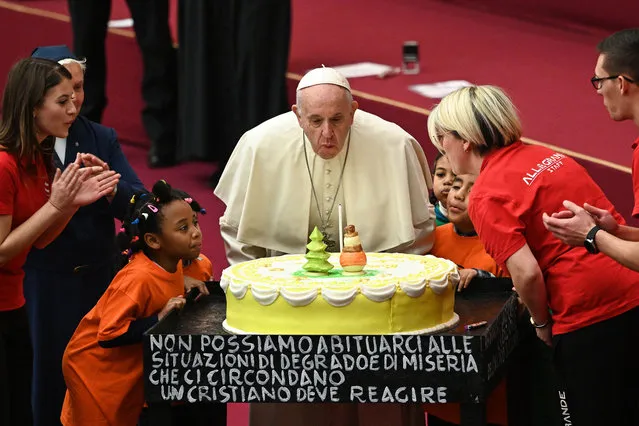 Pope Francis blows the candle of a birthday cake offered to him during an audience for children and families of the Santa Marta dispensary on December 16, 2018 at the Vatican. Pope Francis turns 82 on December 17, 2018. (Photo by Vincenzo Pinto/AFP Photo)