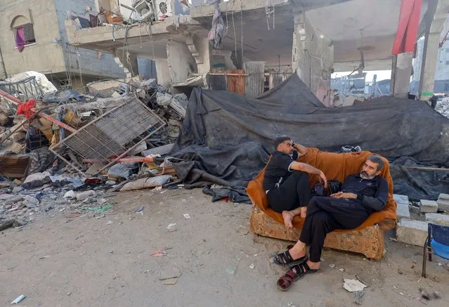Palestinian Mohammed Hamdan, who lost 35 family members of three generations in an Israeli air strike, rests on a couch near the rubble of his family home that was destroyed in the strike, in Khan Younis in the southern Gaza Strip on November 7, 2023. (Photo by Mohammed Salem/Reuters)