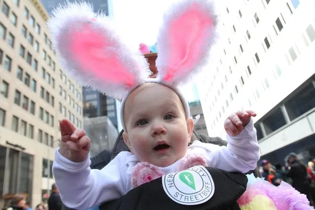 Maelie Swanson held by her father Jeff Swanson participate in the Easter Parade along New York's Fifth Avenue on Sunday, April 5, 2015. (Photo by Tina Fineberg/AP Photo)