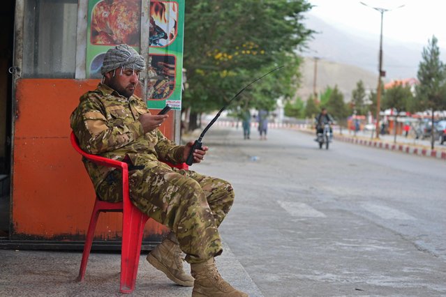 A member of Afghan security force sits along the roadside in Panjshir province on August 14, 2021. (Photo by Ahmad Sahel Arman/AFP Photo)