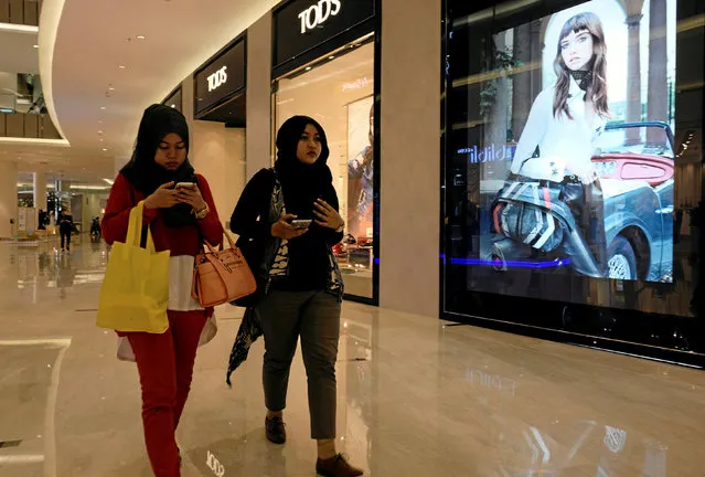 Women walk past a Tod's shoes advertisement at a shopping mall in Jakarta, Indonesia October 25, 2016. (Photo by Reuters/Beawiharta)