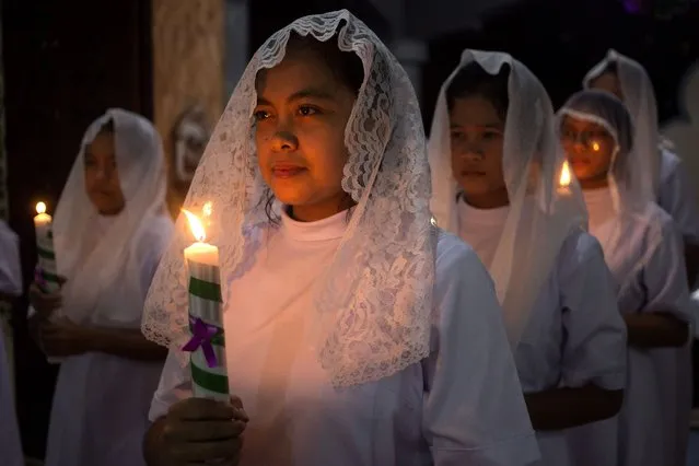 Nuns hold candles during the Christmas Eve mass at Graha Maria Annai Velangkanni Church in Medan, North Sumatra, Indonesia. Sunday, December 24, 2023. (Photo by Binsar Bakkara/AP Photo)