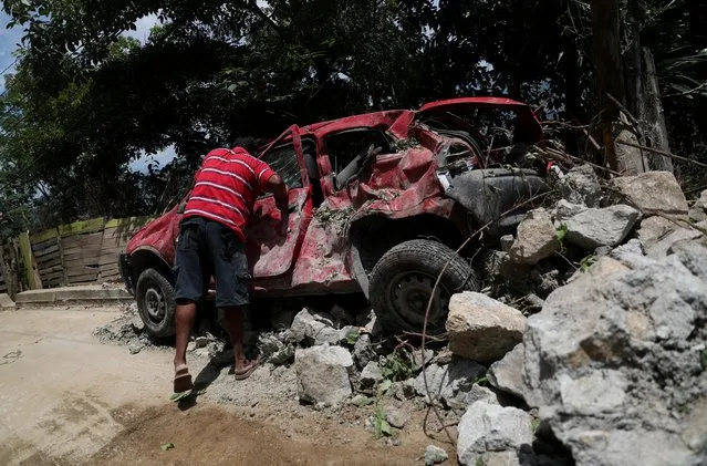 A man stands next to a damaged car in the aftermath of the earthquake in Acapulco, in Guerrero state, Mexico, September 9, 2021. (Photo by Edgard Garrido/Reuters)