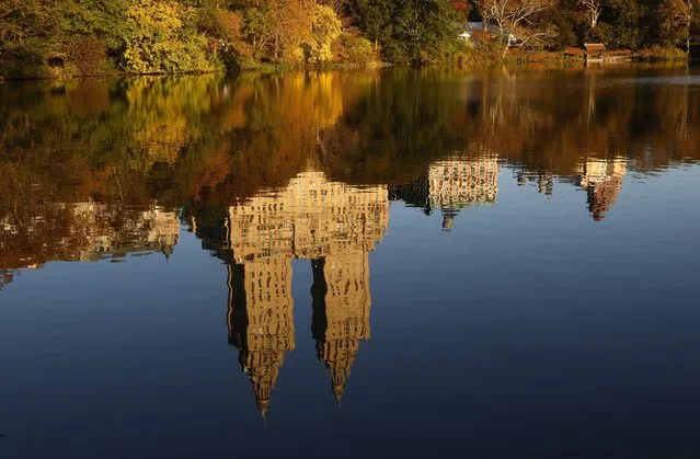 The San Remo apartment building is reflected at sunrise in The Lake in Central Park as trees turn color on November 2, 2023, in New York City. (Photo by Gary Hershorn/Getty Images)