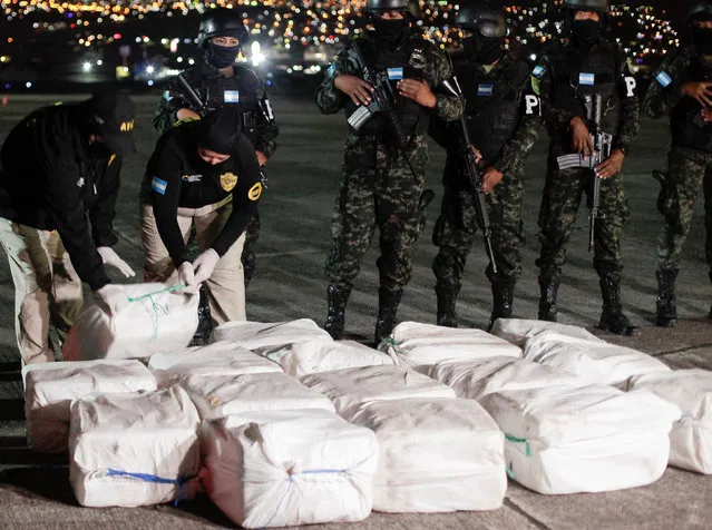Officers of Honduras' Technical Agency for Criminal Investigation place a package containing cocaine seized during a police operation, at a presentation to the media, in Tegucigalpa, Honduras on December 11, 2022. (Photo by Fredy Rodriguez/Reuters)