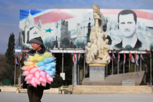 A man sells cotton candy near a banner for Syria's president Bashar al-Assad in Aleppo, Syria January 30, 2017. (Photo by Ali Hashisho/Reuters)