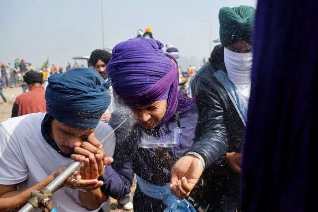 Farmers wash their faces after police fired tear gas towards them during a protest, as farmers march towards New Delhi to press for better crop prices promised to them in 2021, at Shambhu barrier, a border crossing between Punjab and Haryana states, India on February 21, 2024. (Photo by Adnan Abidi/Reuters)