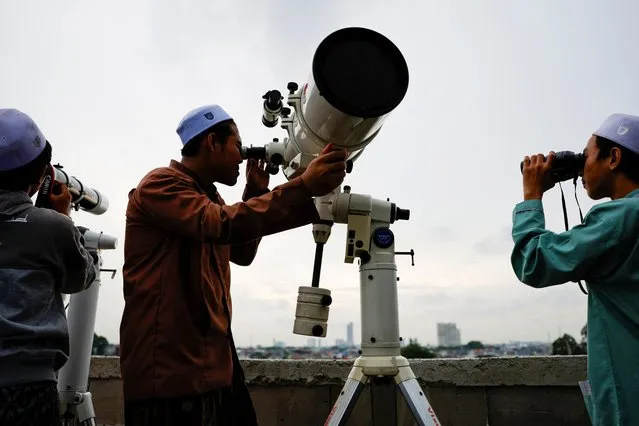 Muslim men look for the position of the moon to mark the first day of the holy fasting month of Ramadan, on the roof of Al-Musyari'in mosque in Jakarta, Indonesia, on March 10, 2024. (Photo by Willy Kurniawan/Reuters)
