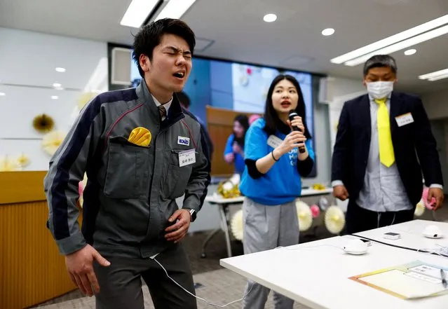 Masaya Shibasaki, 26, an employee of EXEO Group Inc., reacts as he tries the VR electrical device Perionoid, developed by Osaka Heart Cool, which releases electrical stimulation that feels like women's menstrual pain, during a workshop ahead of International Women's Day at the company headquarters in Tokyo, Japan on March 7, 2024. (Photo by Issei Kato/Reuters)
