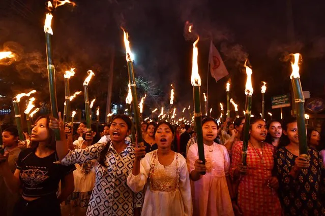 Members of the All Assam Students' Union (AASU) take part in a torch rally as they protest against the implementation of the Citizenship Amendment Act (CAA) in Guwahati on March 12, 2024. India's interior ministry said March 11 it was enacting a citizenship law that critics say discriminates against Muslims, just weeks before the world's most populous country heads into a general election. (Photo by Biju Boro/AFP Photo)