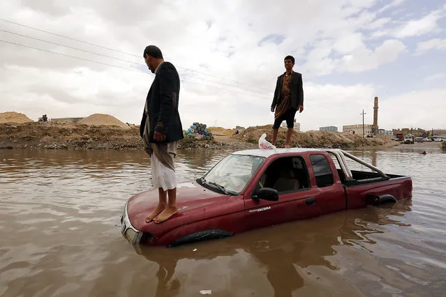 Yemenis stand on a car at a flooded street following heavy rain, in Sana’a, Yemen, 13 April 2016. Torrential rain hit Sanaa and most parts of Yemen as summer temperatures soar. (Photo by Yahya Arhab/EPA)