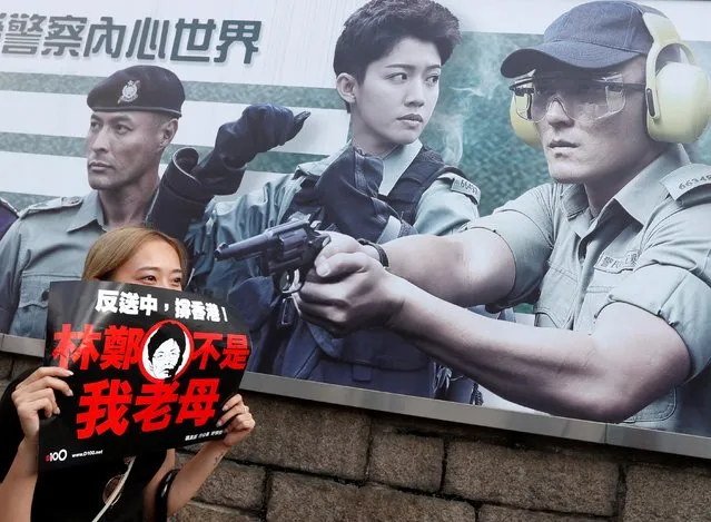 A protester holds a placard next to a recruiting banner at the Hong Kong police headquarters reading “Let yourself experience the feeling of being a police officer” as she attends a demonstration demanding Hong Kong's leaders to step down and withdraw the extradition bill, in Hong Kong, China, June 16, 2019. (Photo by Jorge Silva/Reuters)