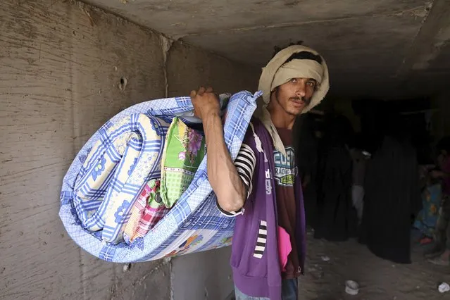 A man carries his luggage as he leaves an underground water tunnel with other displaced people after they were forced to flee their home due to ongoing air-strikes carried out by the Saudi-led coalition in Sanaa May 2, 2015. (Photo by Mohamed al-Sayaghi/Reuters)