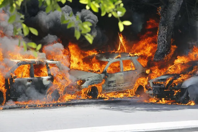 Cars burn after a poweful car bomb in Mogadishu, Somalia, Wednesday, April 17, 2019. (Photo by Farah Abdi Warsameh/AP Photo)