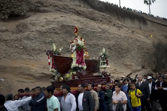 Fishermen carry the statue of Saint Peter during a procession in Lima, Peru, Monday, June 29, 2015. (Photo by Rodrigo Abd/AP Photo)