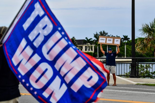 A man holds a sign reading “Lock him up” as supporters of former US President and Republican presidential candidate Donald Trump gather near his residence at Mar-a-Lago as they react after he was convicted in his criminal trial, in Palm Beach, Florida, on May 30, 2024. A panel of 12 New Yorkers were unanimous in their determination that Donald Trump is guilty as charged – but for the impact on his election prospects, the jury is still out. The Republican billionaire was convicted of all 34 charges in New York on May 30, 2024, and now finds himself bidding for a second presidential term unsure if he'll be spending 2025 in the Oval Office, on probation or in jail. (Photo by Chandan Khanna/AFP Photo)