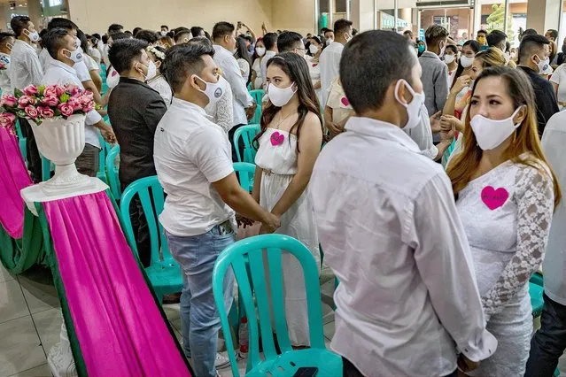 Couples take part in a mass wedding ceremony a day before Valentines Day on February 13, 2022 in Quezon city, Metro Manila, Philippines. The Philippines has eased restrictions this month as daily cases of COVID-19 gradually drop. The country has so far recorded more than 3,630,000 infections of the coronavirus, reporting more than 54,000 deaths. (Photo by Ezra Acayan/Getty Images)