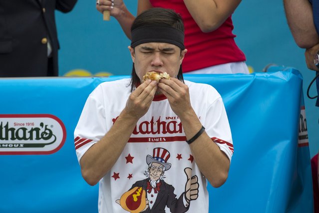 Matt Stonie consumes hot dogs during the annual Fourth of July 2015 Nathan's Famous Hot Dog Eating Contest in Brooklyn, New York July 4, 2015. Stonie defeated 8 time champion Joey Chestnut 62-60, according to local media. (Photo by Andrew Kelly/Reuters)
