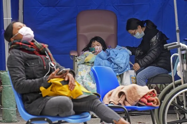 People, including current hospital patients, showing COVID-19 symptoms wait at a temporary holding area outside Caritas Medical Centre in Hong Kong Wednesday, February 16, 2022. China's leader Xi Jinping took a personal interest in Hong Kong's outbreak, saying it was the local government's “overriding task” to control the situation, a Hong Kong newspaper said on Wednesday. (Photo by Vincent Yu/AP Photo)