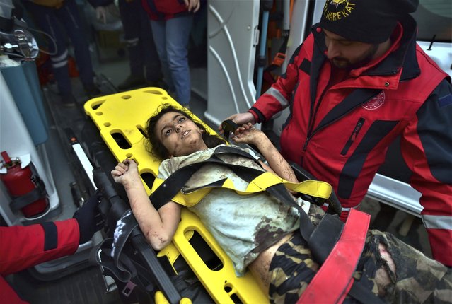 A rescuer takes care of a young girl rescued 4 days after the earthquake, in Kahramanmaras, southern Turkey, early Friday, February 10, 2023. Rescuers have pulled more survivors from beneath collapsed buildings, but hopes were fading of finding many more people alive after the catastrophic earthquake in Turkey and Syria. (Photo by Ismail Coskun/IHA via AP Photo)