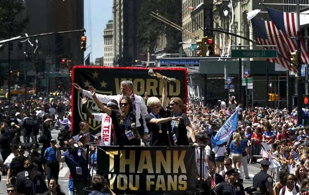 U.S. women's soccer player Megan Rapinoe (C) holds the Wold Cup trophy as she rides a float with teammate Carli Lloyd (L), Coach Jill Ellis (R) and New York City Mayor Bill de Blasio during the ticker tape parade up Broadway in lower Manhattan to celebrate their World Cup final win over Japan in New York, July 10, 2015. (Photo by Mike Segar/Reuters)