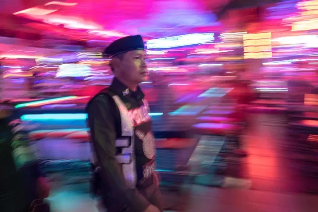 This photo taken on March 29, 2017 shows a Thai policeman patrolling Walking Street in Pattaya. (Photo by Roberto Schmidt/AFP Photo)