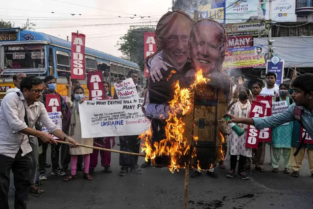 Activists of All India Democratic Students Organization burn a cutout of Russian President Vladimir Putin and US President Joe Biden during a protest against the Russian invasion on Ukraine, in Kolkata, India, Thursday, March 3, 2022. The protesters were demanding that Indian government should bring back students studying in Ukraine and Russia should stop the war. (Photo by Bikas Das/AP Photo)